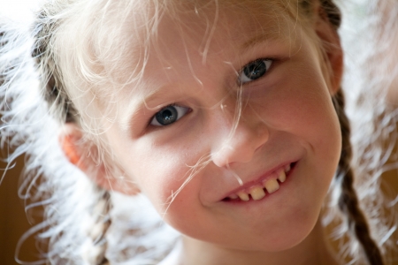 closeup portrait of funny smiling little girlの写真素材