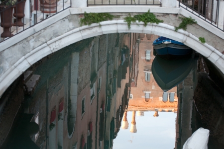 reflection of bridge and houses on Venetian canal water surfaceのeditorial素材