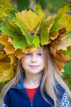 portrait of beautiful caucasian little girl in yellow autumn maple leaves crownのeditorial素材