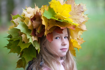 portrait of beautiful caucasian little girl in yellow autumn maple leaves crownのeditorial素材