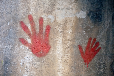 two red hands tracks painted on the grey wall closeupの写真素材