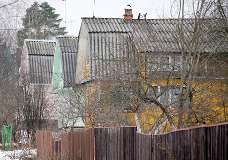 row of three old wooden houses on countryside streetの写真素材