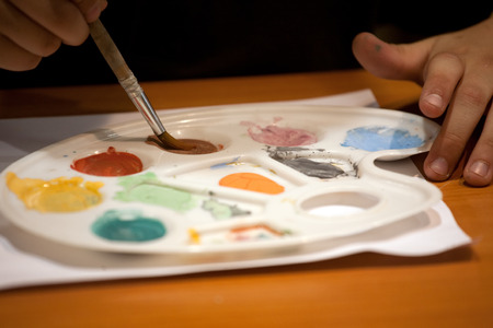 palette with color paints and child hands closeupの写真素材
