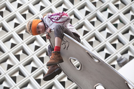 small funny girl on modern architecture wall backgroundの写真素材