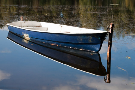 boat and its reflection in calm water surfaceの写真素材