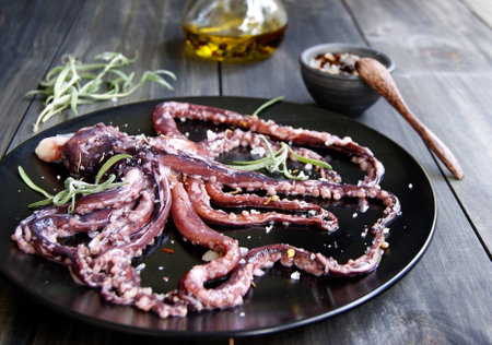 Fresh squid with an asparagus on a black plateの写真素材