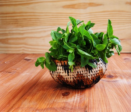 Bunch of fresh mint in a basket on dpletenoy dereayannom tableの写真素材