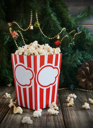 popcorn in the cup on the background of Christmas trees and Christmas decorations, New Year offer, selective focusの写真素材