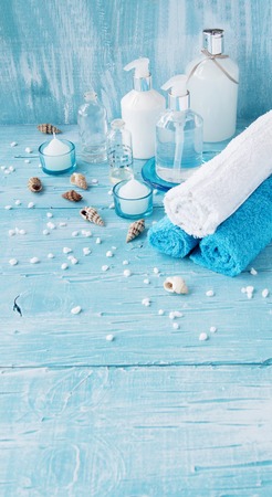 White flowers lying on a blue wooden board with shell and candle Spa setの写真素材