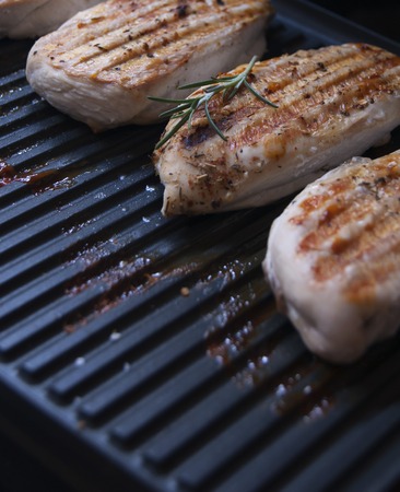 chicken breasts with herbs spices on the grillの写真素材