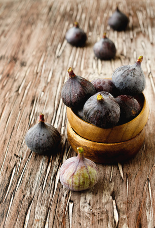 raw figs in wooden bowl on the table, selective focusの写真素材