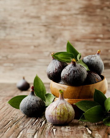 raw figs in wooden bowl on the table, selective focusの写真素材