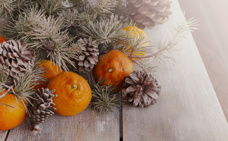 Christmas balls with fir branches, tangerines, pine cones, and glasses with champagne, cardの写真素材