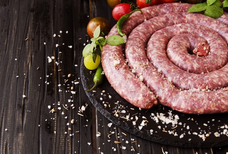 raw beef sausages with rosemary and spices on a wooden table, South African boereworsの写真素材