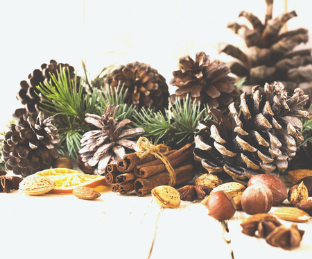 New Year or Christmas composition with walnuts, mulled wine, hazelnuts, pistachios in canvas bags with fir branches and cones. wood background, selective focusの写真素材
