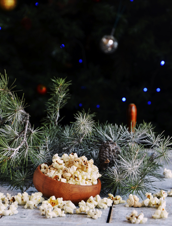New Year or Christmas composition with popcorn , hazelnuts, pistachios in canvas bags with fir branches and cones. wood background, selective focusの写真素材