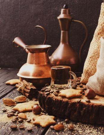 Turkish coffee in a small cup, cookies, cinnamon nuts and Turks for the preparation, selective focusの写真素材