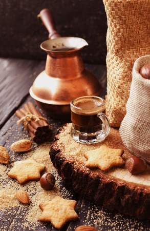 Turkish coffee in a small cup, cookies, cinnamon nuts and Turks for the preparation, selective focusの写真素材