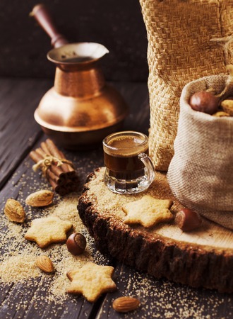 Turkish coffee in a small cup, cookies, cinnamon nuts and Turks for the preparation, selective focusの写真素材