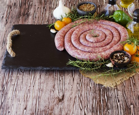 raw beef sausages with rosemary and spices on a wooden table, South African boereworsの写真素材