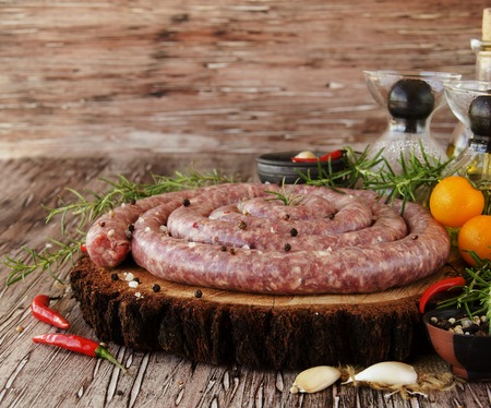 raw beef sausages with rosemary and spices on a wooden table, South African boereworsの写真素材