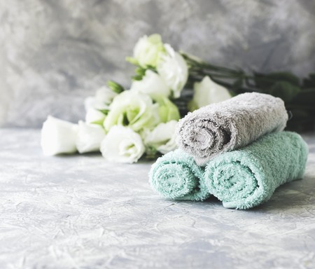 stack of towels marble table set with flowers for spa space under the text, selective focusの写真素材