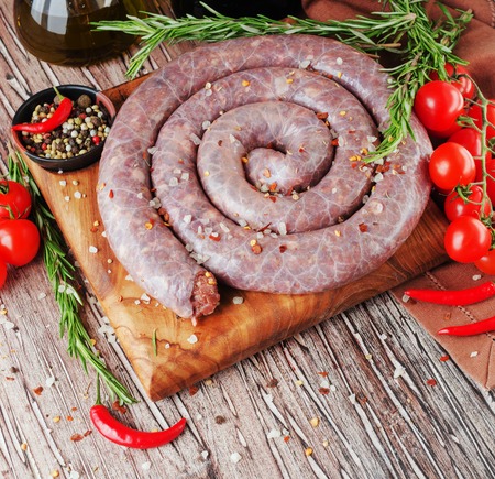 raw beef sausages with rosemary and spices on a wooden table, South African boereworsの写真素材