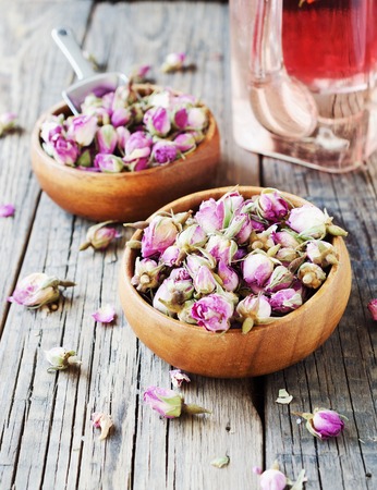 small dry buds of roses, tea, karkade, in wooden bowls, selective focusの写真素材