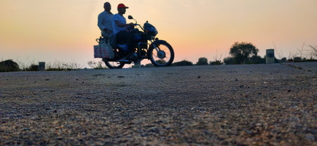 Motorcycle on the road at sunset. Motorcycle with two people on the road.
