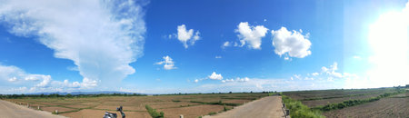 Panorama of blue sky with white clouds and road in the countryside