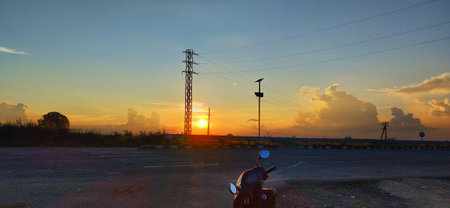 Motorcycle in the road at sunset. Beautiful sky and clouds.の写真素材