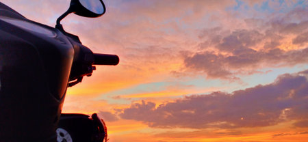 motorcycle silhouette on sunset sky background, panoramic view