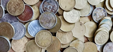 Coins of different countries are scattered on the table close-up