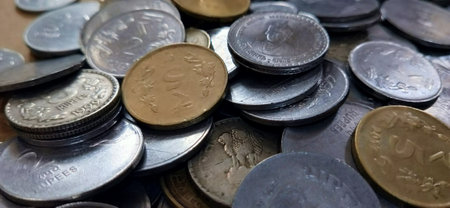 Coins of different countries are scattered on the table. Selective focus.