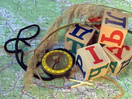 Compass, two matches, ear and bricks with cyrillic alphabet letters on a geographic map