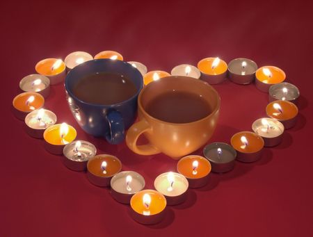  Valentine Day composition with two stream tea cups in the center of candle burn heart (on red background). Make specially some dark as a background.の写真素材