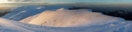 Mountain ridge sunset panorama view in golden-pastel tones from last evening sunrays (Ukraine, Carpathian Mt's, Drahobrat ski resort). Ten shots stitch image.の写真素材