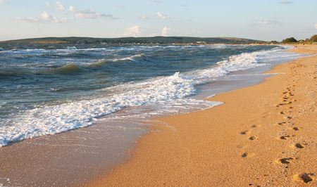 Sea surf wave and sandy beach with footprints