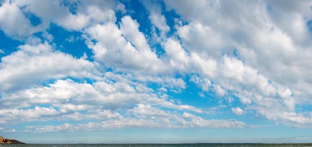Blue height sky above the sea surface with clouds. Four shots stitch image.の写真素材