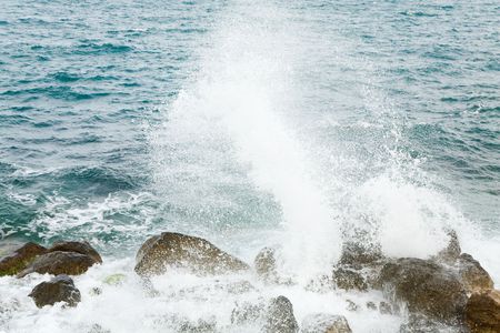 Stony sea coastline  and wave with splashesの写真素材
