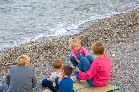 happy family (mother with small children and grandmother) relax on beachの写真素材