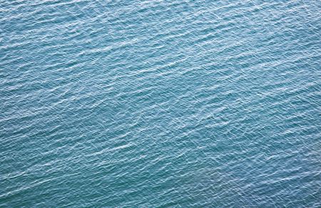 transparent coastal azure water surface with some stones on bottomの写真素材