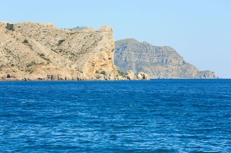 Summer rocky coastline and military base on rock top  (Alchak Cape; Sudak Town environs, Crimea, Ukraine).の写真素材