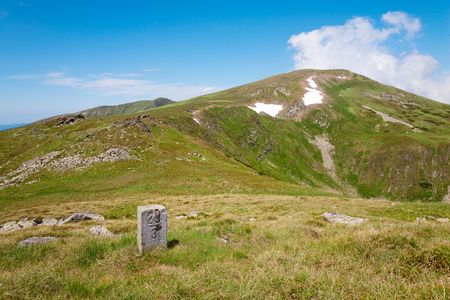 stony post on summer mountain ridge and snow on mountainside(Ukraine, Carpathian Mountains)の写真素材