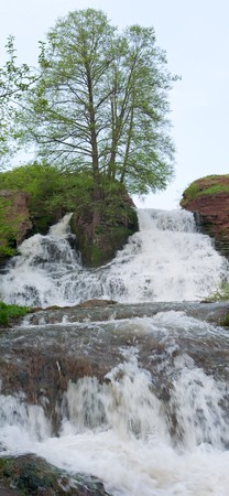 Spring high Dzhurinsky waterfall and tree on sky background (Nirkov village, Zalischyky Raion, Ternopil Region, Ukraine). Two shots stitch image.の写真素材