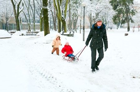 Happy family (mother with small boy and girl) in winter city parkの写真素材