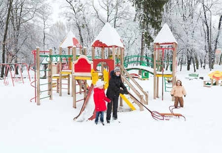 Family (mother with small boy and girl) in winter city parkの写真素材