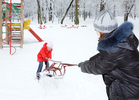 Happy family (mother with small boy and girl) in winter city parkの写真素材