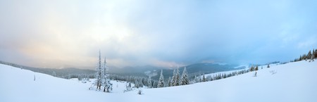 Evening twilight winter calm mountain panorama with sheds group and mount ridge behind (Carpathian Mountains, Ukraine).  Three shots stitch image.の写真素材