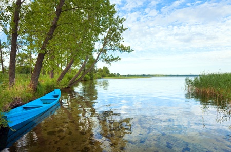 Old wooden fishing boat near the summer lake shore (Svityaz Lake, Ukraine)の写真素材